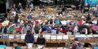 Menschen sehen sich am sonnigen Sonntagvormittag die Waren an den Ständen des Flohmarktes im Mauerpark in Berlinan