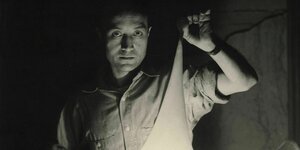 Isamu Noguchi hält eine Lichtskulptur Isamu Noguchi hält eine Lichtskulptur