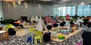 Ein großer Raum mit Spielsachen, Spieltischen und kleinen Tipis.