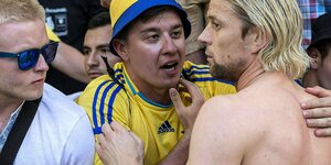 Anatoli Timoschtschuk mit freiem Oberkörper unterhält sich mit einem ukrainischen Fan