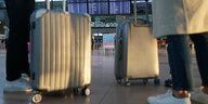 Menschen mit Koffern warten in einem Flughafen