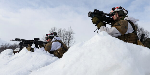 Norwegische Soldaten mit angelegtem Gewehr im Schnee während einer Militärübung der NATO