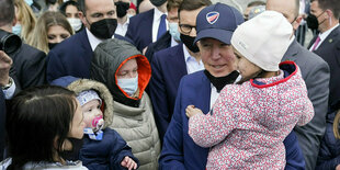 Präsident der USA, trägt bei seinem Besuch im PGE Narodowy-Stadion, in dem ukrainische Kriegsflüchtlinge untergebracht sind, ein Kind. Biden hat Polen angesichts des russischen Angriffskriegs in der Ukraine die Bündnistreue der Nato zugesichert.