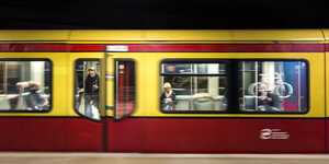 S-Bahn braust los, alter rot-gelber Waggon