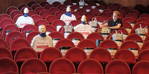 Puppen sitzen im Zuschauerraum eines Theaters