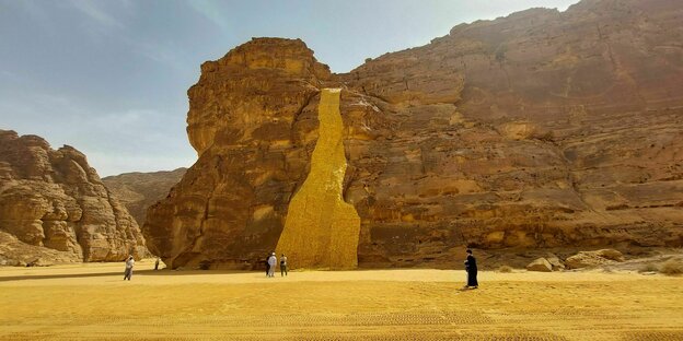 Ein goldener "Wasserfall" als Skulptur in der Wüste.