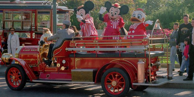 Besucher auf einem Wagen mit Mickey und Minni Maus