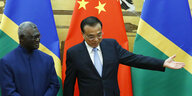 Minister Sogavare und der chinesische Premier Li Keqiang bei einer Zeremonie vor den Flaggen der Salomonen und Chinas