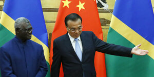 Minister Sogavare und der chinesische Premier Li Keqiang bei einer Zeremonie vor den Flaggen der Salomonen und Chinas