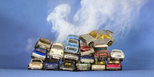Alte Spielzeugautos auf einem Stapel und eine Rauchwolke