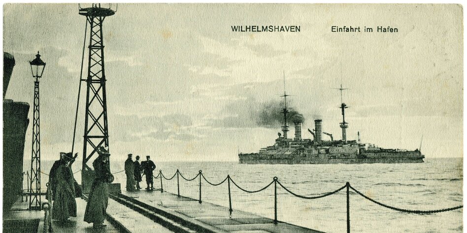 Eine alte Postkarte zeigt ein Kriegsschiff vor Wilhelmshaven