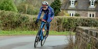 Emily Bridges fährt auf dem Fahrrad durch ein Dorf in Wales