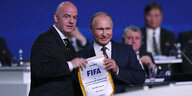 Fifa-Präsident Gianni IOnafantino überreicht Wladimir Puztin einen Fifa-Wimpel