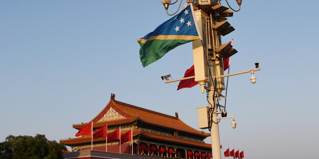 Über einem chinesisch-aussehenden Gebäude flattert die salomonische Fahne im Wind