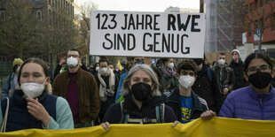 Demonstranten ziehen mit Transparenten durch die Straßen