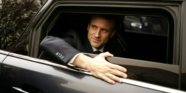 Emmanuel Macron sieht aus einem offenen Autofenster