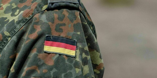 Bundeswehrsoldat trägt auf seiner Tarnjacke ein Abzeichen der Deutschlandfahne