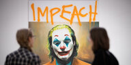 Bild vom Joker, darüber steht "impeach", davor zwei Ausstellungsbesucher