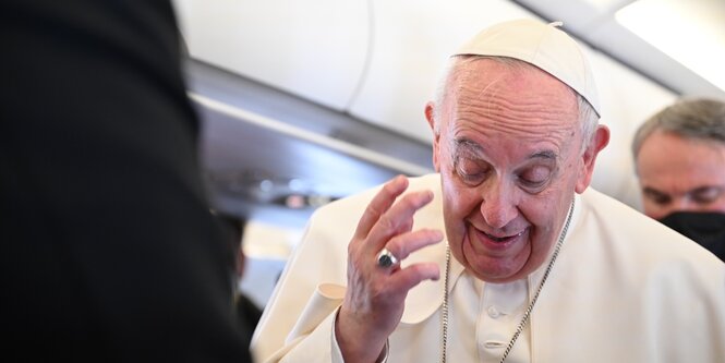 Papst Franziskus gestikuliert an Bord eines Flugzeugs