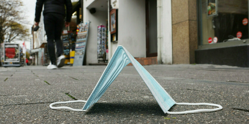 ine Maske liegt in der Altstadt von Düsseldorf auf dem Boden.