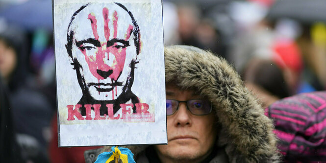 Eine Demonstratin mit einem Anti-Putin-Plakat