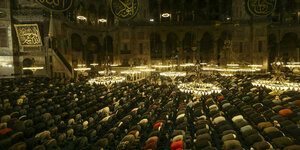 Hunderte von Menschen knien zum Gebet im großen Saal der Hagia Sophia