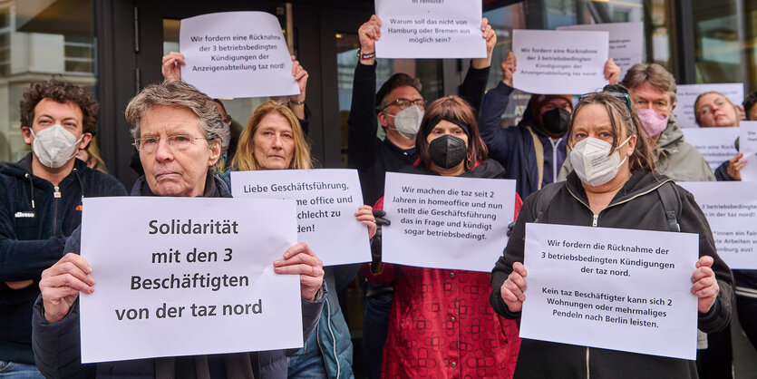 Menschen protestieren mit Plakaten