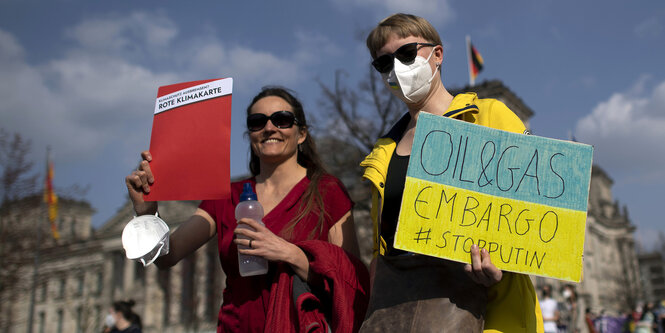 Ein mann und eine Frau tragen Protestschilder