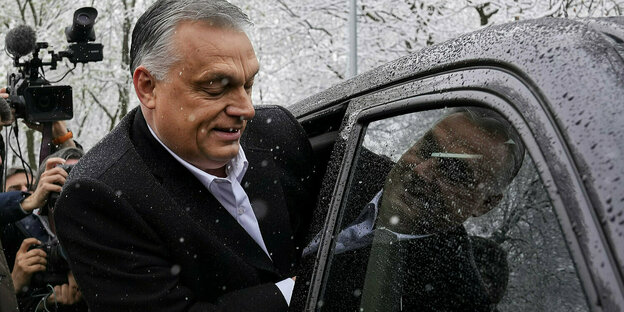 Victor rban steigt in ein Auto, es fällt Schnee