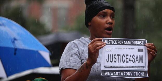 Eine Frau hält ein Poster hoch, das eine Verurteilung im Fall Samuel Dubose forert