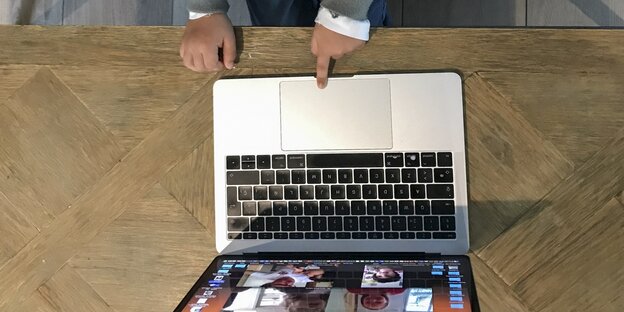 Kinderhände auf der Tastatur eines Laptops