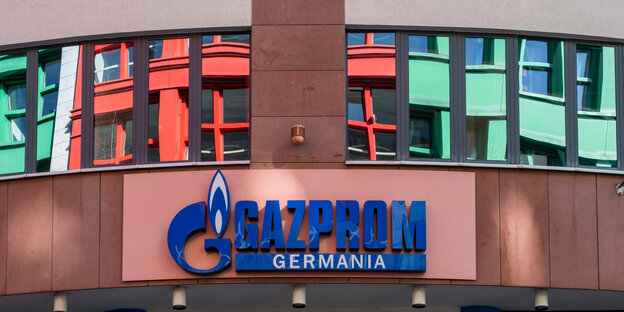 Logo der Gazprom Germania an einem Gebäude, Spiegelungen im Fenster