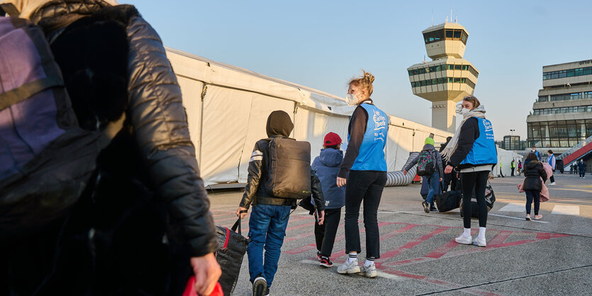 Das Foto zeigt Ukraine-Flüchtlinge vor Zelten am Ankunftszentrum am Exflughafen Tegel.