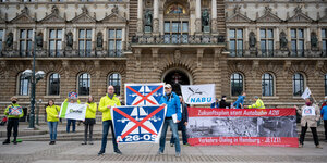 Vertreter des Nabu und des BUND präsentieren Banner vor dem Hamburger Rathaus