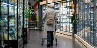 Eine Frau schiebt einen Einkaufswagen durch den Supermarkt