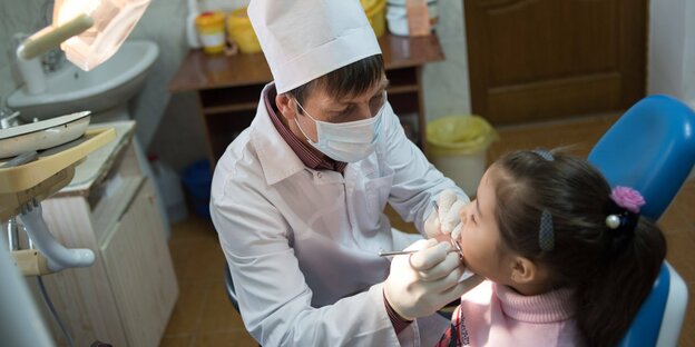 Ein Mädchen wird von einem Zahnarzt behandelt