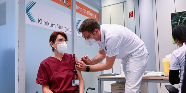Die Klinikmitarbeiterin Birgit Schüle lässt sich im Klinikum Stuttgart von Impfarzt Daniel Kaiser impfen.