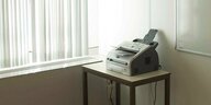 Ein Faxgerät steht in der Ecke eines leeren Büroraumes