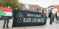 Demonstranten halten ein Plakat mit der Aufschrift "Black Lifes Matter".