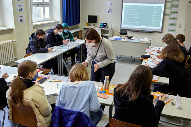 Lehrerin hilft Schuläer:innen im Klassenzimmer