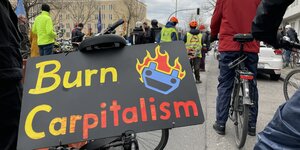 Fahrrad auf Demo mit Schild "Burn Carpitalism"