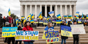 Menschen mit Ukraine-Plakaten