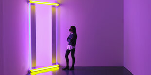 Eine Frau betrachtet die Arbeit „untitled (to Barnett Newman) four, 1971“ von Dan Flavin