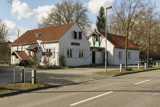 Ein altes Haus mit weißen Wänden und einem roten Ziegeldach Ein altes Haus mit weißen Wänden und einem roten Ziegeldach