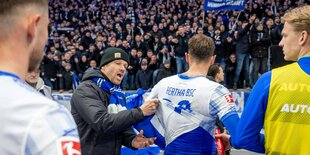 Hertha-Fan fasst vor der Kurve einem Spieler ans Trikot