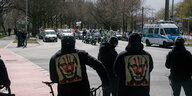 Demonstranten tragen auf ihren Jacken Aufnäher mit Putin-Porträt, auf dem "Killer" steht