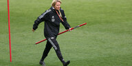 Bundestrainerin Martina Voss-Tecklenburg steckt Trainingsstanden in den Rasen