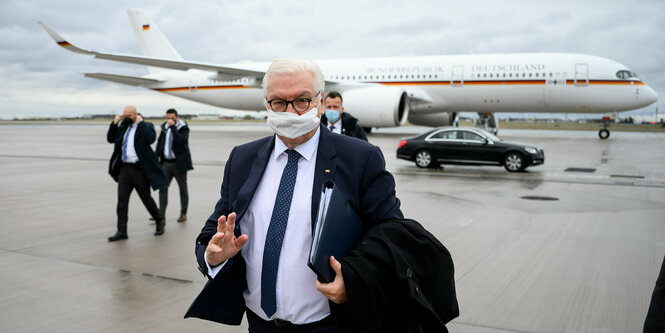 Steinmeier auf einem Rollfeld, im Hintergrund Flugzeug