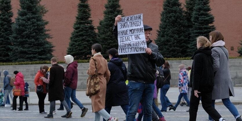 Oleg Orlow steht auf dem Roten Platz in Moskau und hält ein Schild in die Höhe