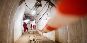 Mitarbeiter und Besucher stehen in einem Schacht im still gelegten Eisenerzbergwerk Schacht Konrad.